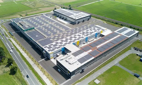 Luftaufnahme eines modernen Gewerbeparks mit Photovoltaikanlagen auf den Dächern – Symbol für nachhaltige Immobilienentwicklung der Pletzer Gruppe.