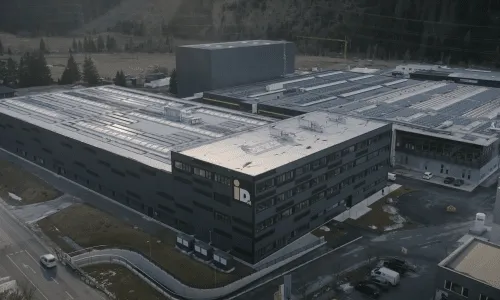 Industriestandort mit modernem Gebäudekomplex in alpiner Umgebung – repräsentiert die innovativen Technologien und Fertigungskompetenz der Pletzer Industrie.